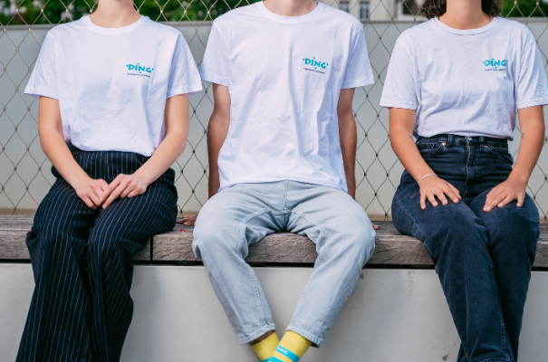 Drei Personen sitzen auf einer Bank