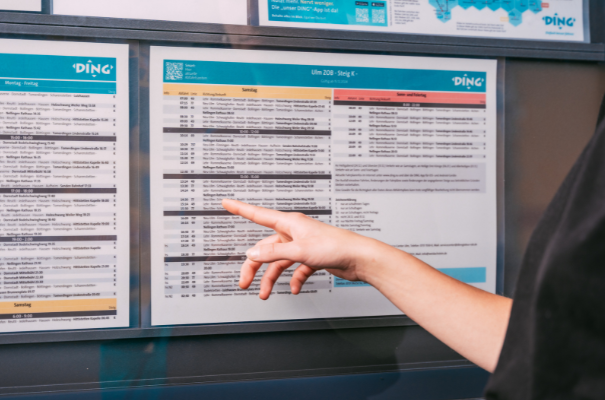 Person zeigt auf Fahrplan