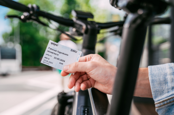 Person mit Fahrradticket und Fahrrad