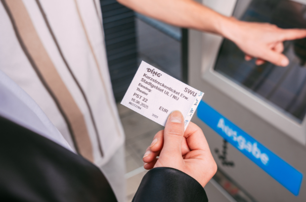 Person hält Fahrkarte Kurzstreckenticket in der Hand