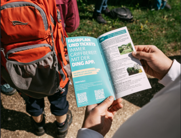 Person hält Fyler "Wandern mit dem Albverein" in der Hand